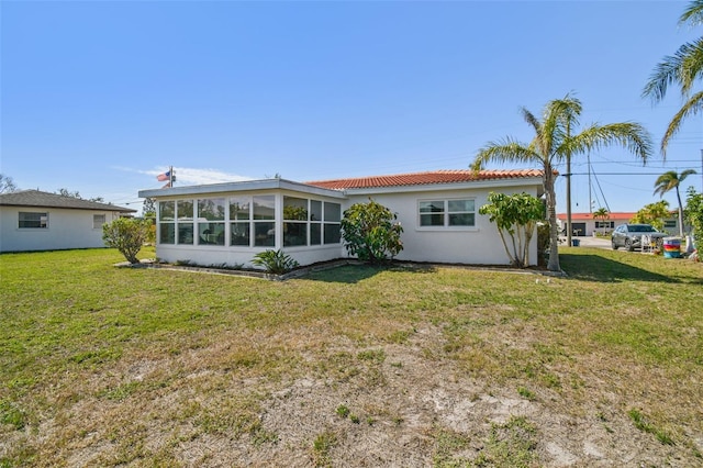 back of house with a yard and a sunroom