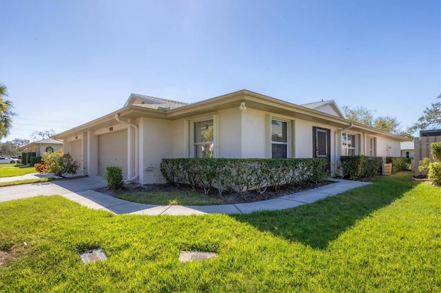 view of property exterior with a garage, concrete driveway, a lawn, and stucco siding