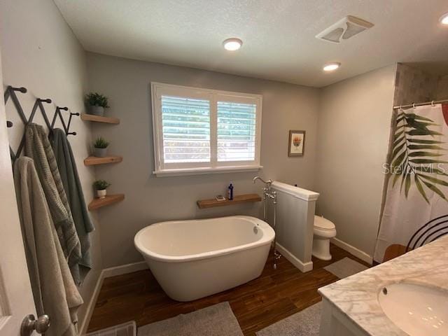 full bathroom with vanity, toilet, separate shower and tub, and hardwood / wood-style floors