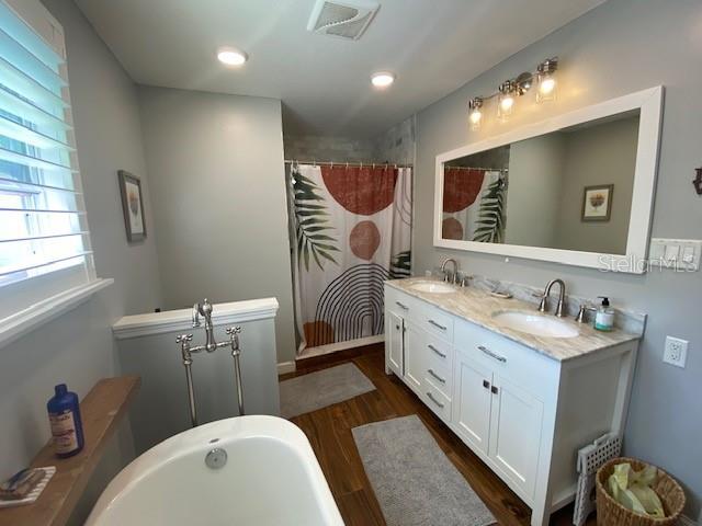 bathroom with vanity, wood-type flooring, and shower with separate bathtub