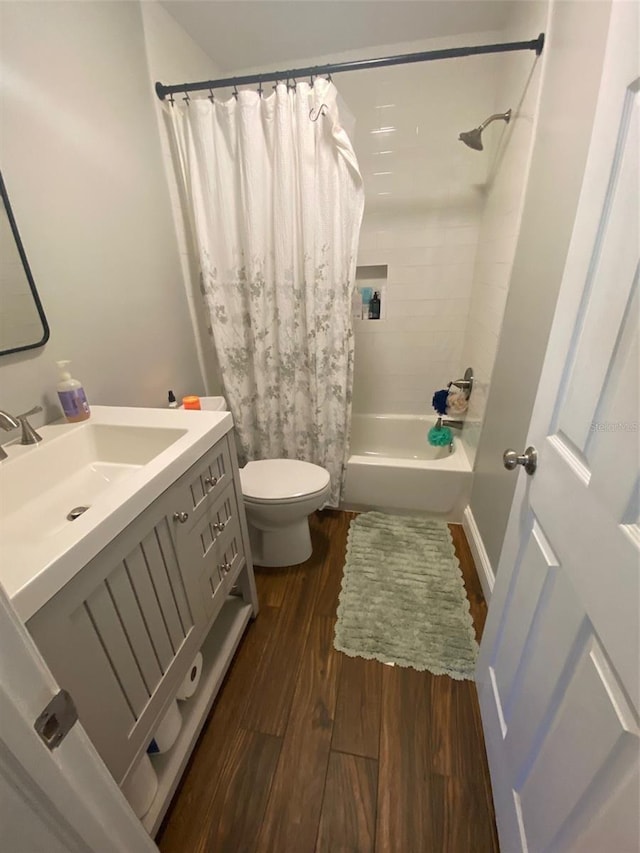 bathroom with shower / bath combination with curtain, vanity, toilet, and wood finished floors