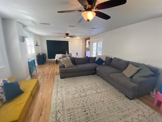 living area with a healthy amount of sunlight, light wood-style floors, and visible vents