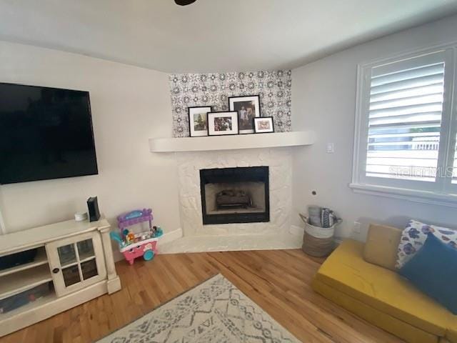 living room with a large fireplace and wood finished floors