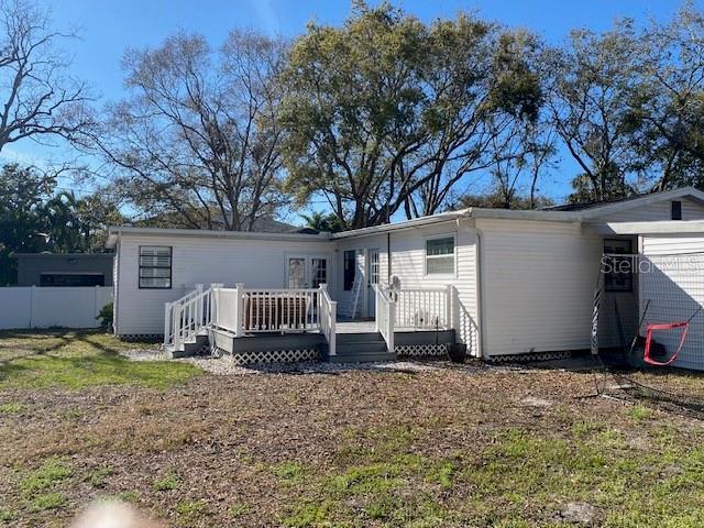 rear view of property featuring fence and a deck