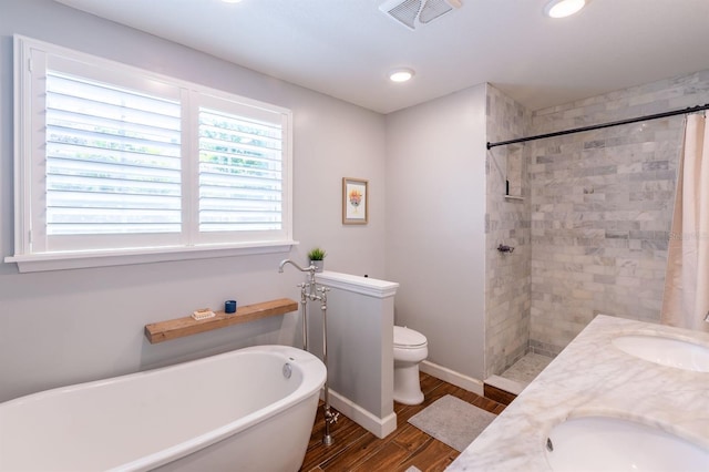 full bathroom with a freestanding tub, wood finished floors, visible vents, and a sink