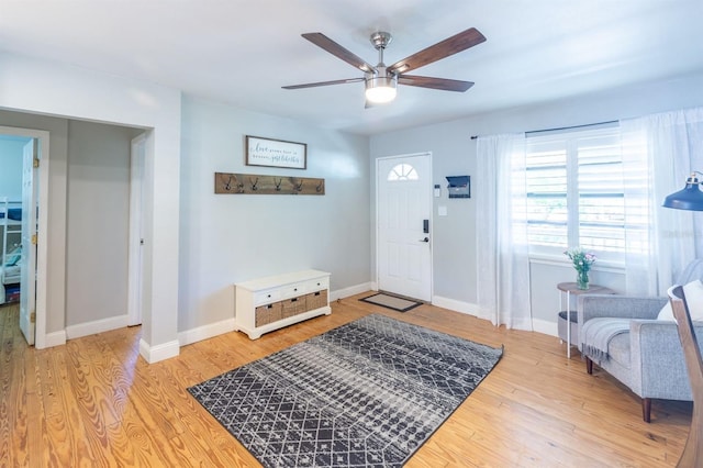 entryway with baseboards, wood finished floors, and a ceiling fan