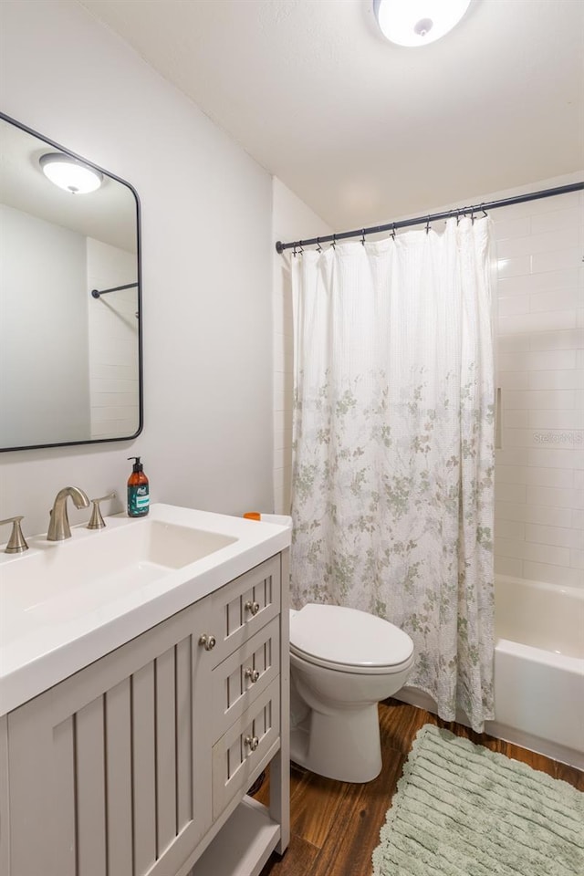 full bathroom featuring toilet, vanity, shower / tub combo, and wood finished floors