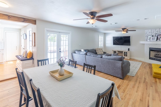 dining room featuring visible vents, light wood-style flooring, a ceiling fan, and french doors