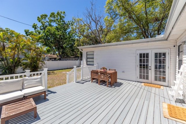 wooden terrace featuring outdoor lounge area, french doors, and fence