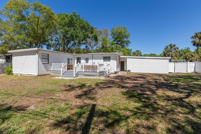 exterior space featuring a deck, a front yard, and fence
