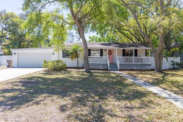 single story home featuring a porch, concrete driveway, an attached garage, and fence