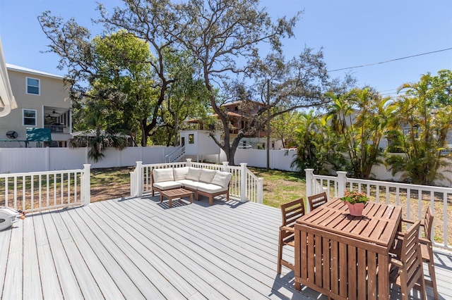 wooden deck with an outdoor hangout area and a fenced backyard
