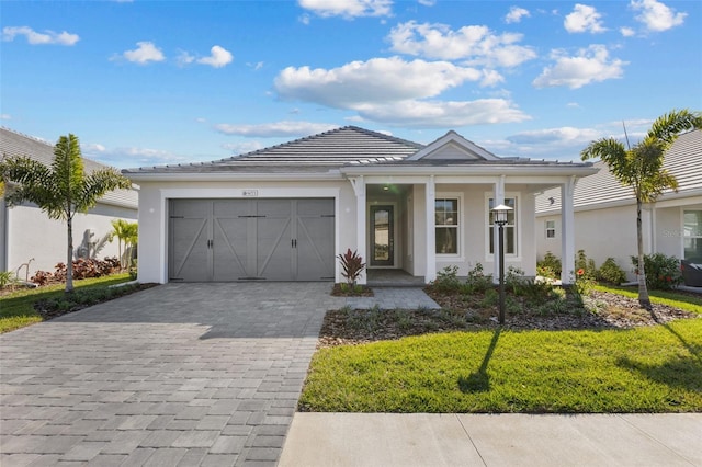 view of front of property with a garage, covered porch, and a front lawn