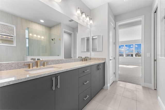 bathroom featuring tile patterned flooring, vanity, and a shower with shower door