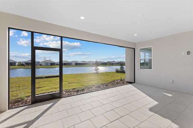 unfurnished sunroom featuring a water view