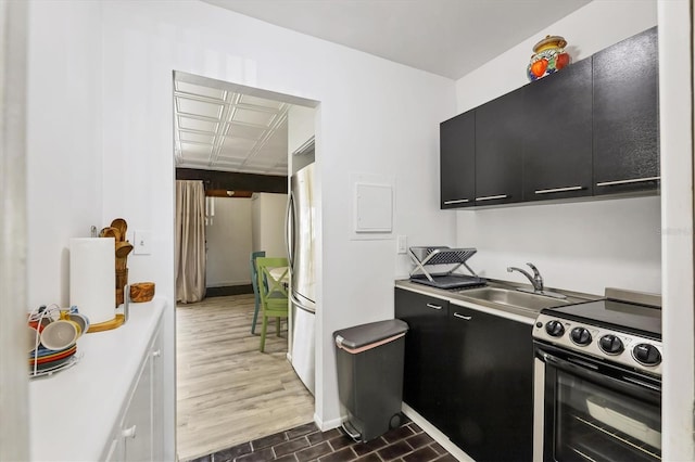 kitchen with electric stove, dark hardwood / wood-style floors, sink, and stainless steel refrigerator