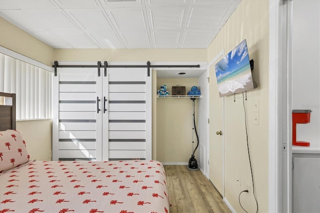 bedroom featuring a closet, hardwood / wood-style flooring, and a barn door