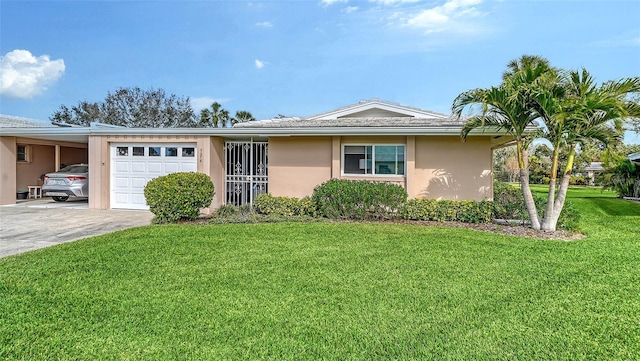 single story home featuring concrete driveway, an attached carport, an attached garage, a front lawn, and stucco siding