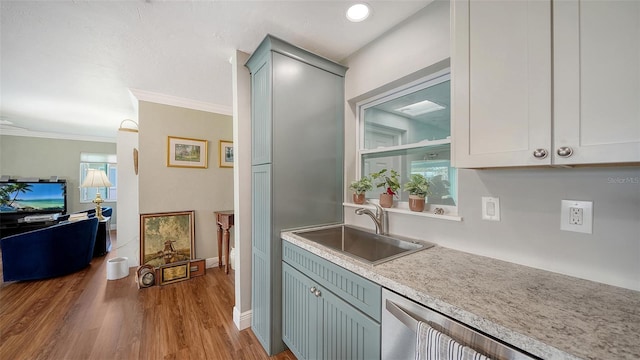 kitchen featuring a sink, light wood-style floors, light countertops, dishwasher, and crown molding