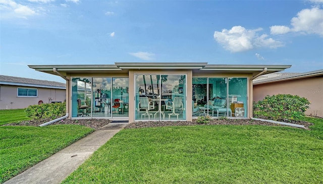 back of house featuring a sunroom and a yard