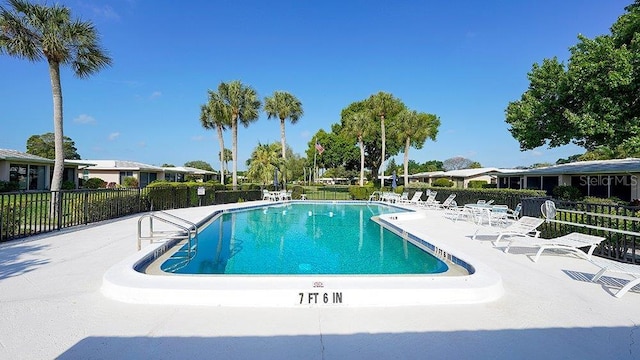 community pool with fence and a patio