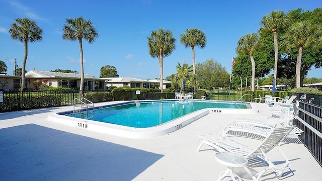 pool with a patio and fence