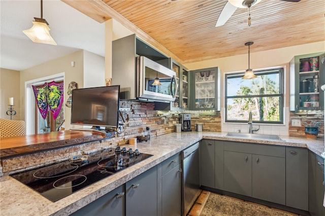 kitchen featuring sink, gray cabinets, appliances with stainless steel finishes, backsplash, and decorative light fixtures