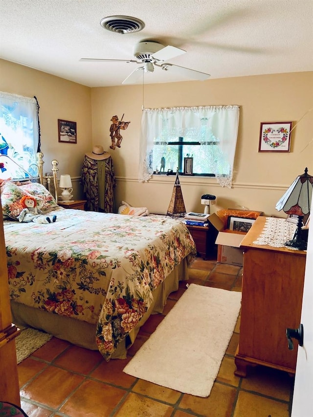 bedroom with ceiling fan and a textured ceiling