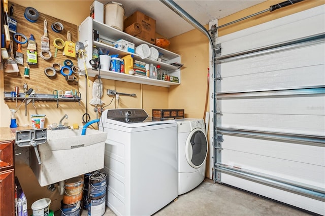 clothes washing area with sink, washer and dryer, and baseboard heating