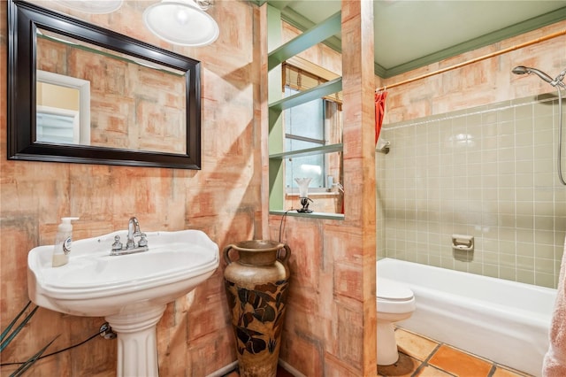 bathroom featuring tile patterned flooring, tiled shower / bath combo, and toilet