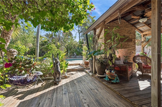 wooden terrace featuring ceiling fan and a pool