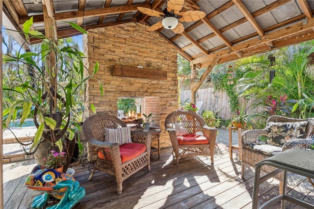 wooden terrace with ceiling fan and an outdoor stone fireplace