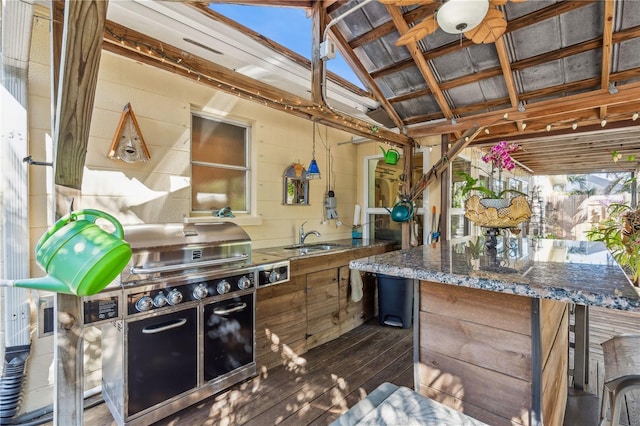 view of patio with sink, a grill, ceiling fan, and exterior kitchen