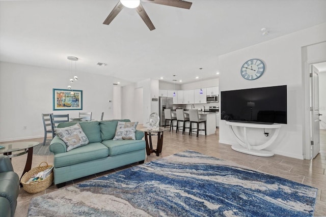 living area with ceiling fan, visible vents, baseboards, and recessed lighting