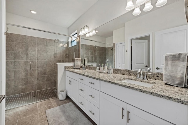 full bathroom with a stall shower, a sink, and double vanity