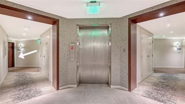 corridor featuring ornamental molding and elevator