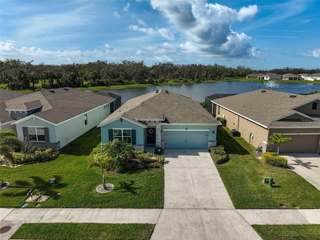 view of front facade featuring a garage, a front yard, a water view, and driveway