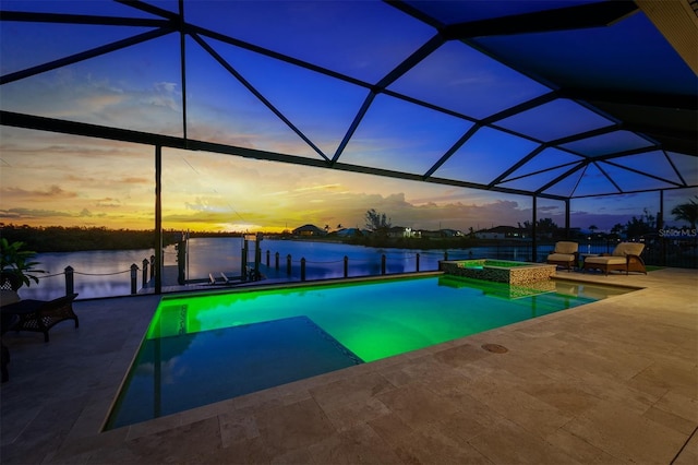 pool at dusk with a water view, an in ground hot tub, a lanai, and a patio