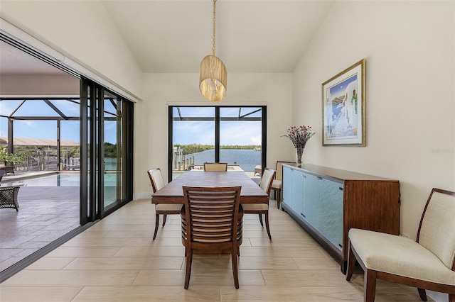 dining room with lofted ceiling, a healthy amount of sunlight, and a water and mountain view