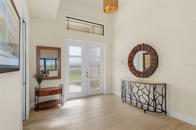 foyer featuring light wood-type flooring and french doors