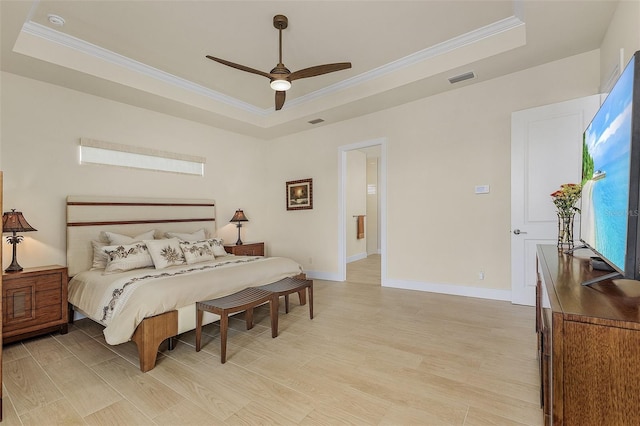 bedroom with a raised ceiling, ornamental molding, and light hardwood / wood-style floors