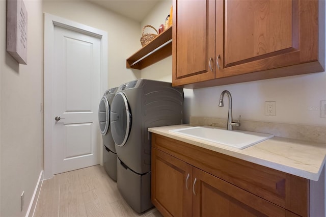 washroom featuring separate washer and dryer, sink, and cabinets