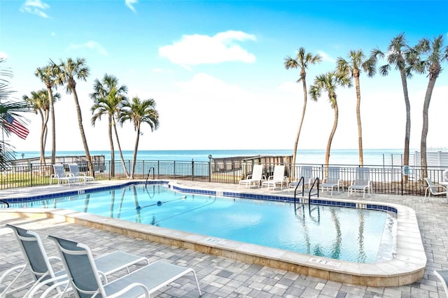 view of pool with a water view and a patio area