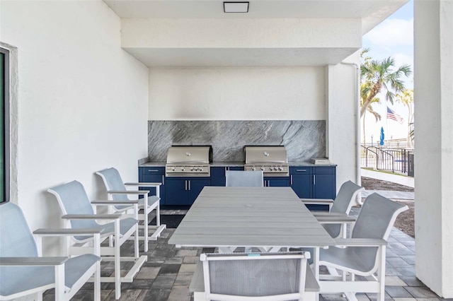 view of patio featuring outdoor dining space, an outdoor kitchen, a grill, and fence