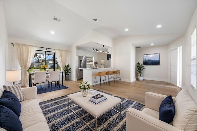 living room with lofted ceiling and light wood-type flooring