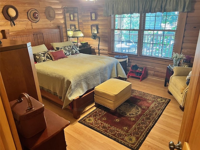 bedroom with wood-type flooring and wooden walls