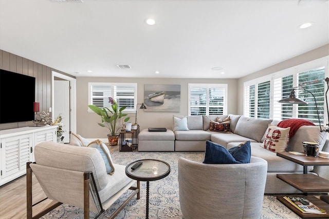 living room featuring wooden walls and light wood-type flooring