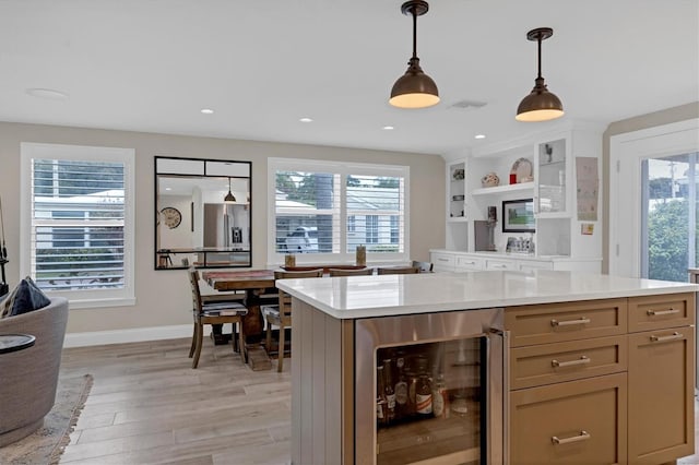 kitchen featuring wine cooler, plenty of natural light, light hardwood / wood-style floors, and hanging light fixtures