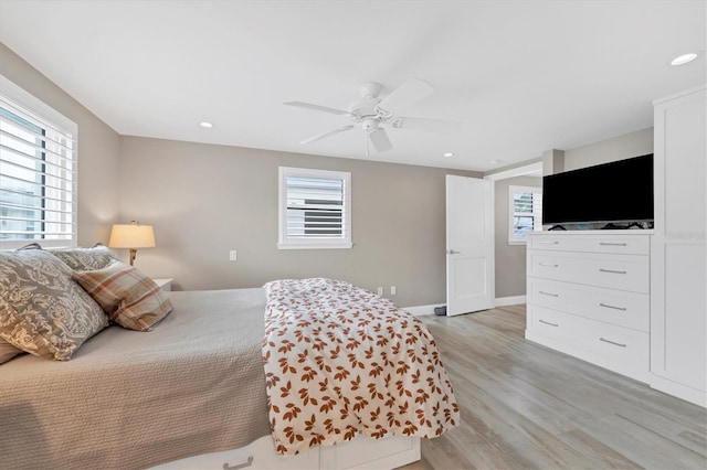 bedroom with multiple windows, light hardwood / wood-style floors, and ceiling fan