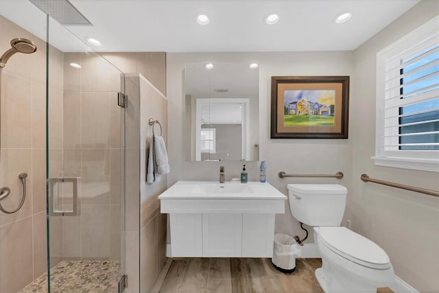 bathroom featuring an enclosed shower, vanity, wood-type flooring, and toilet